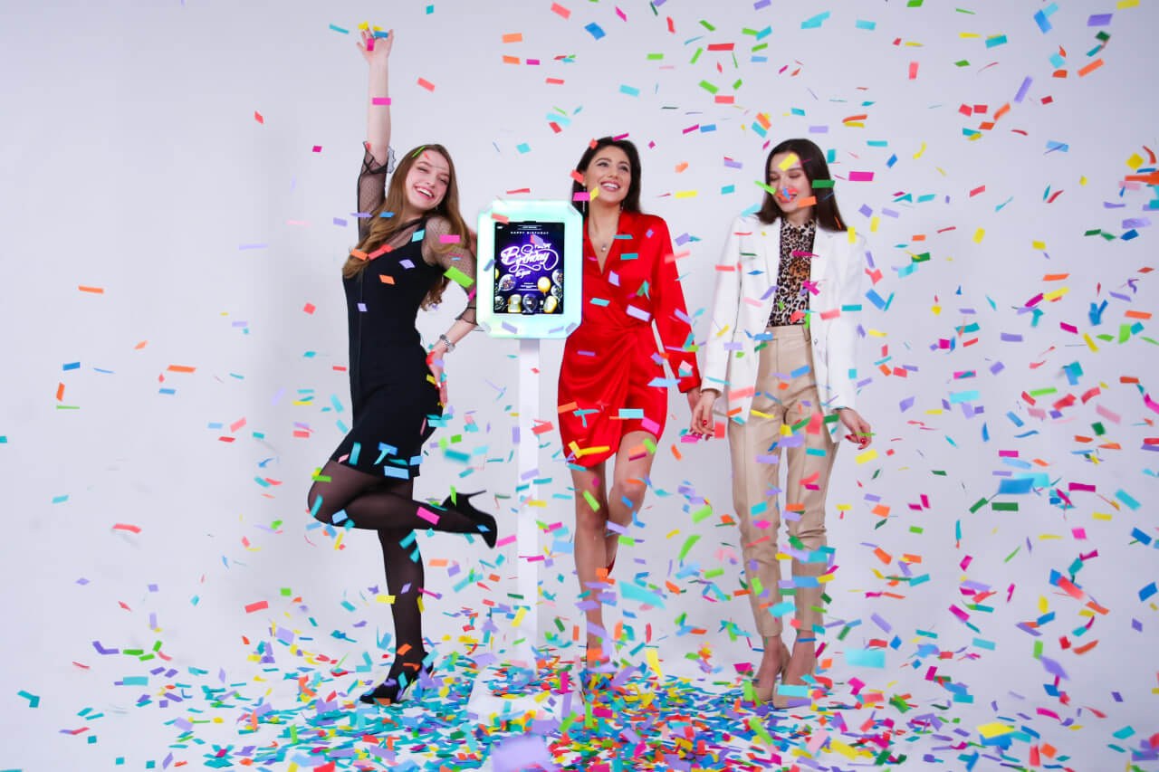 Guests posing beside MixUp Mini in a confetti scene